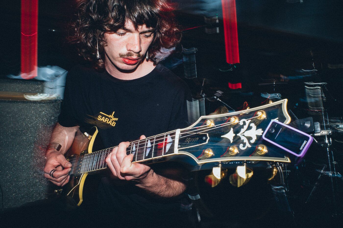 Le guitariste de SMSCR sous une lumière rouge